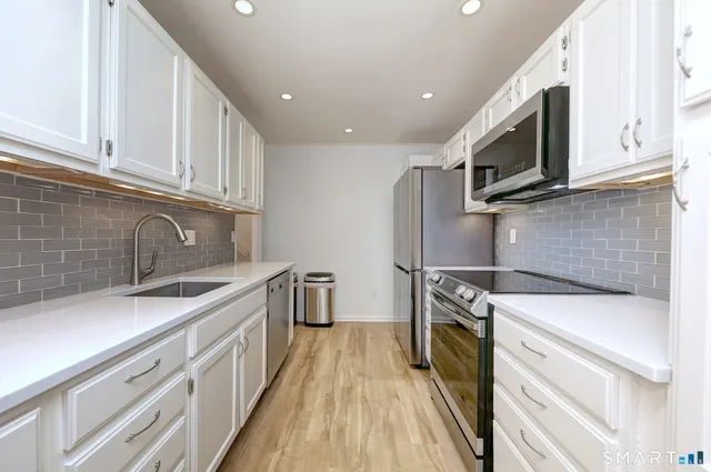a kitchen with stainless steel appliances granite countertop a sink stove and refrigerator