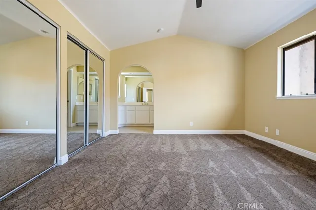 a view of an empty room with window and closet area