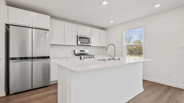 a kitchen with stainless steel appliances a refrigerator sink and microwave