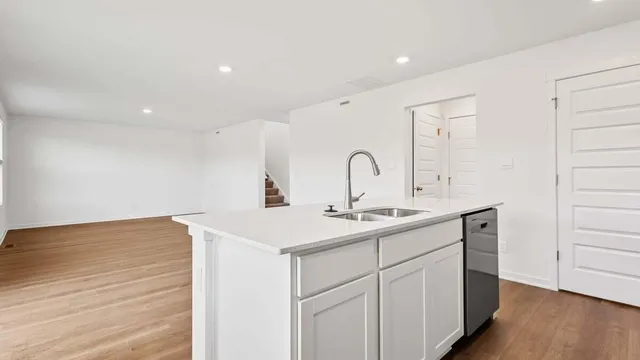a kitchen with a sink cabinets and wooden floor