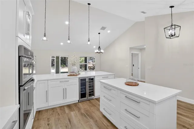 a kitchen with kitchen island a sink and a stove top oven with wooden floor