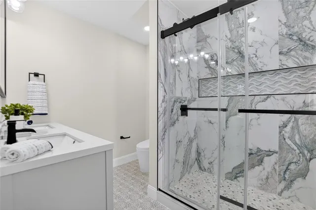 a bathroom with a sink a toilet and shower