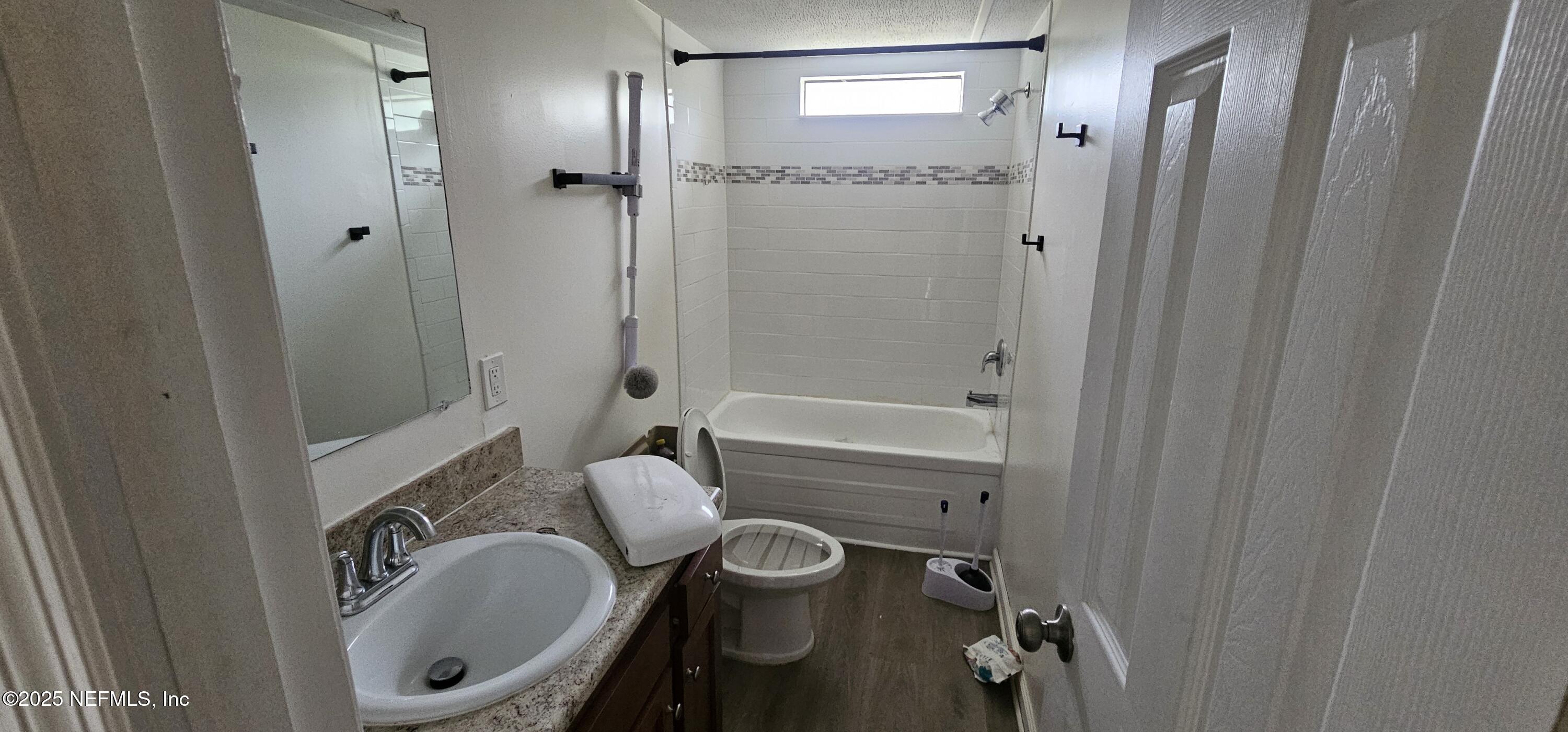 5951 Westwood Road North Jacksonville, FL 32234 - Photo 11 of 33 a bathroom with a granite countertop bathtub shower sink mirror and toilet