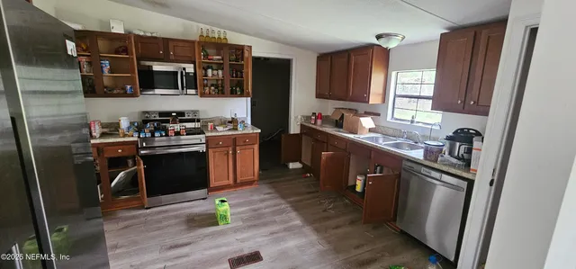 a kitchen with stainless steel appliances granite countertop a stove sink and cabinets