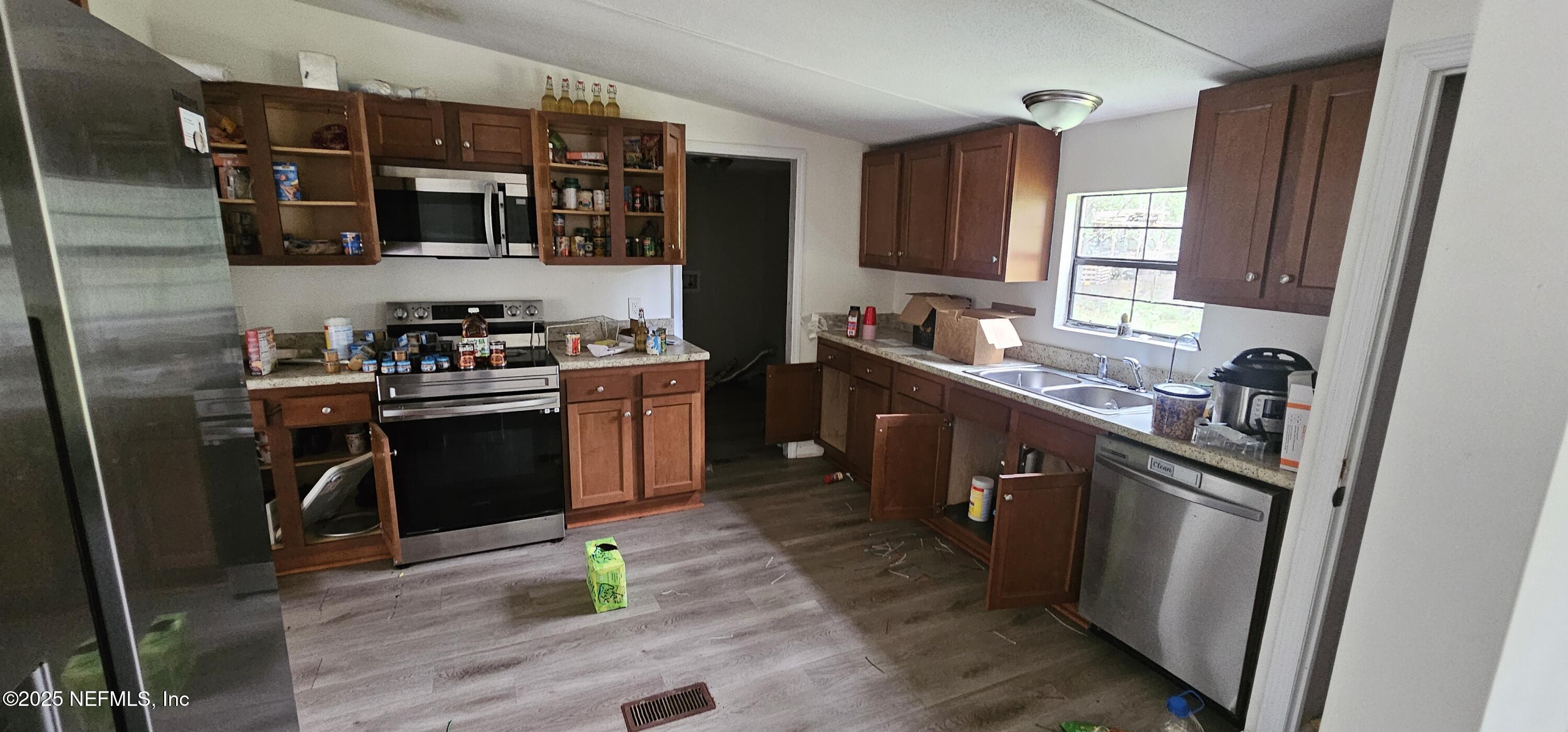 5951 Westwood Road North Jacksonville, FL 32234 - Photo 20 of 33 a kitchen with stainless steel appliances granite countertop a stove sink and cabinets
