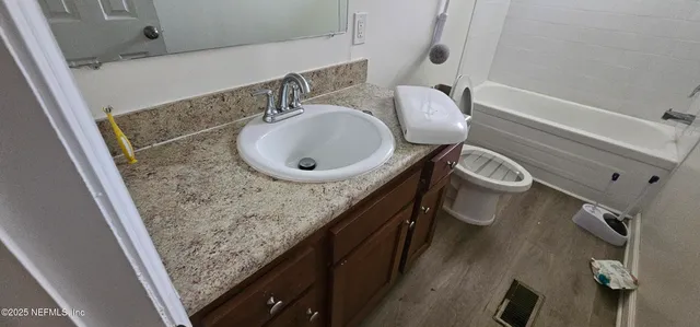 a bathroom with a granite countertop sink a mirror and shower