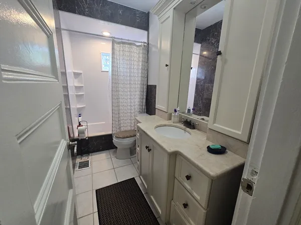 a bathroom with a sink a toilet a mirror and shower