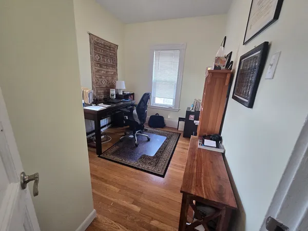 a view of a workspace with furniture and a window