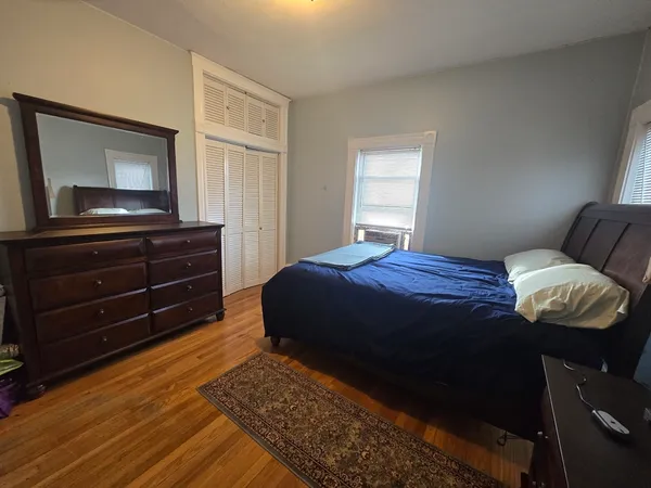 a bedroom with a bed and wooden floor