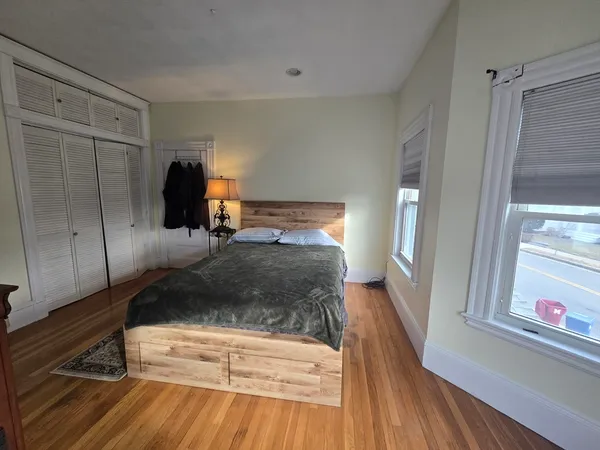 a bedroom with a bed and wooden floor