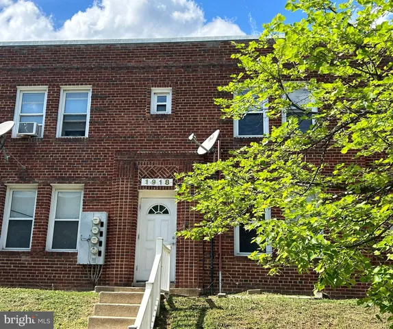a front view of a house with a tree