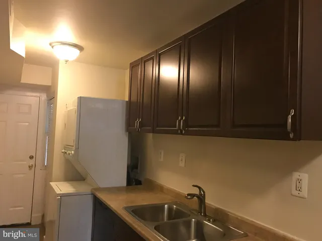 a kitchen with stainless steel appliances granite countertop a sink a stove and a refrigerator with wooden cabinets