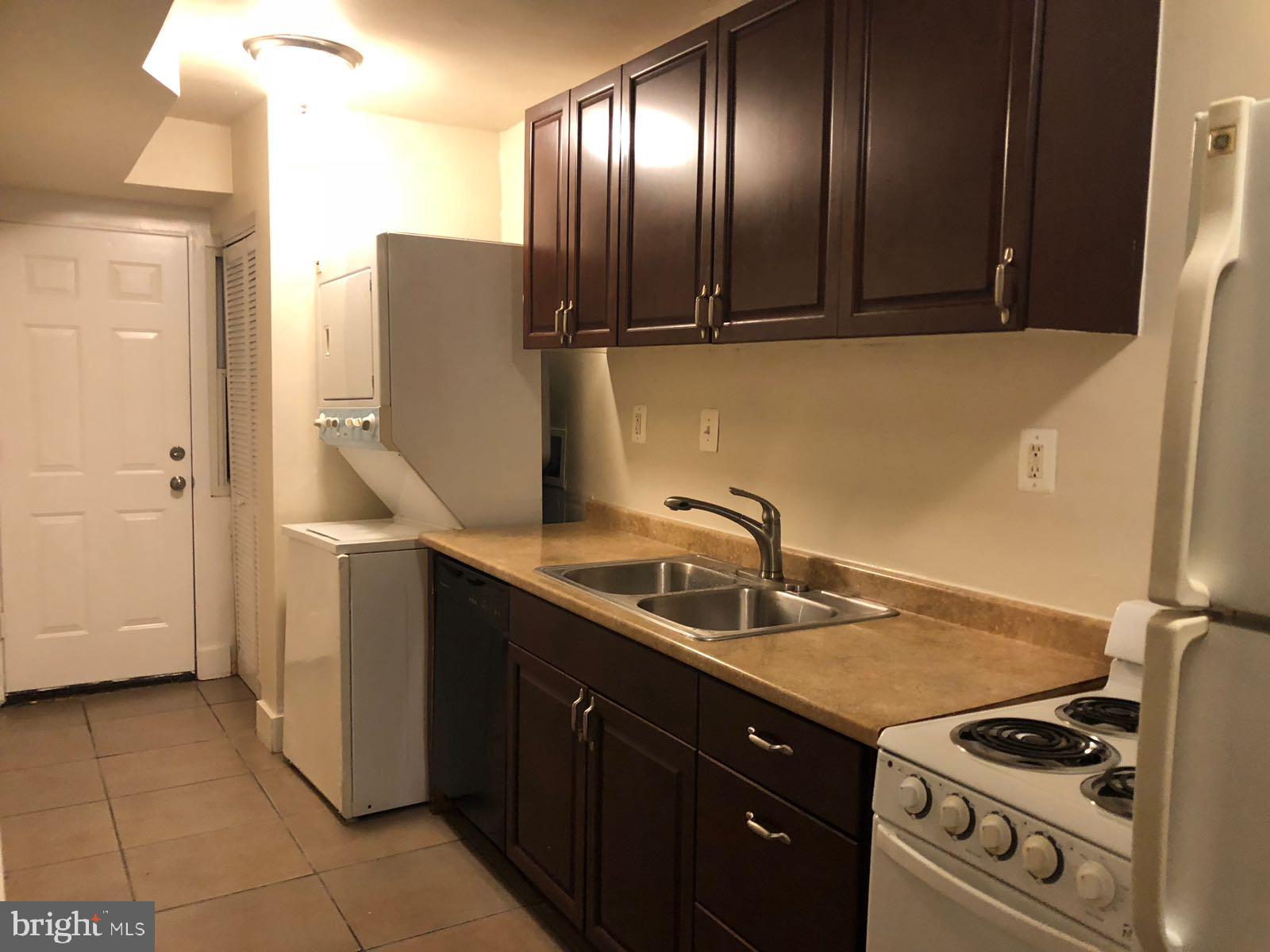 1918 I Street Northeast Washington, DC 20002 - Photo 12 of 29 a kitchen with stainless steel appliances granite countertop a sink a stove and a refrigerator with wooden cabinets