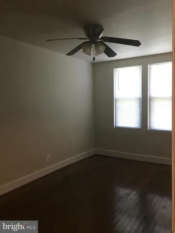 en empty room with wooden floor and windows