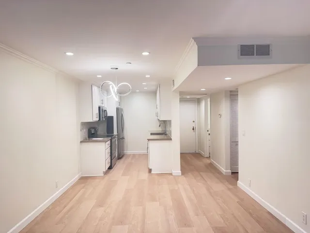 a open kitchen with white cabinets and stainless steel appliances