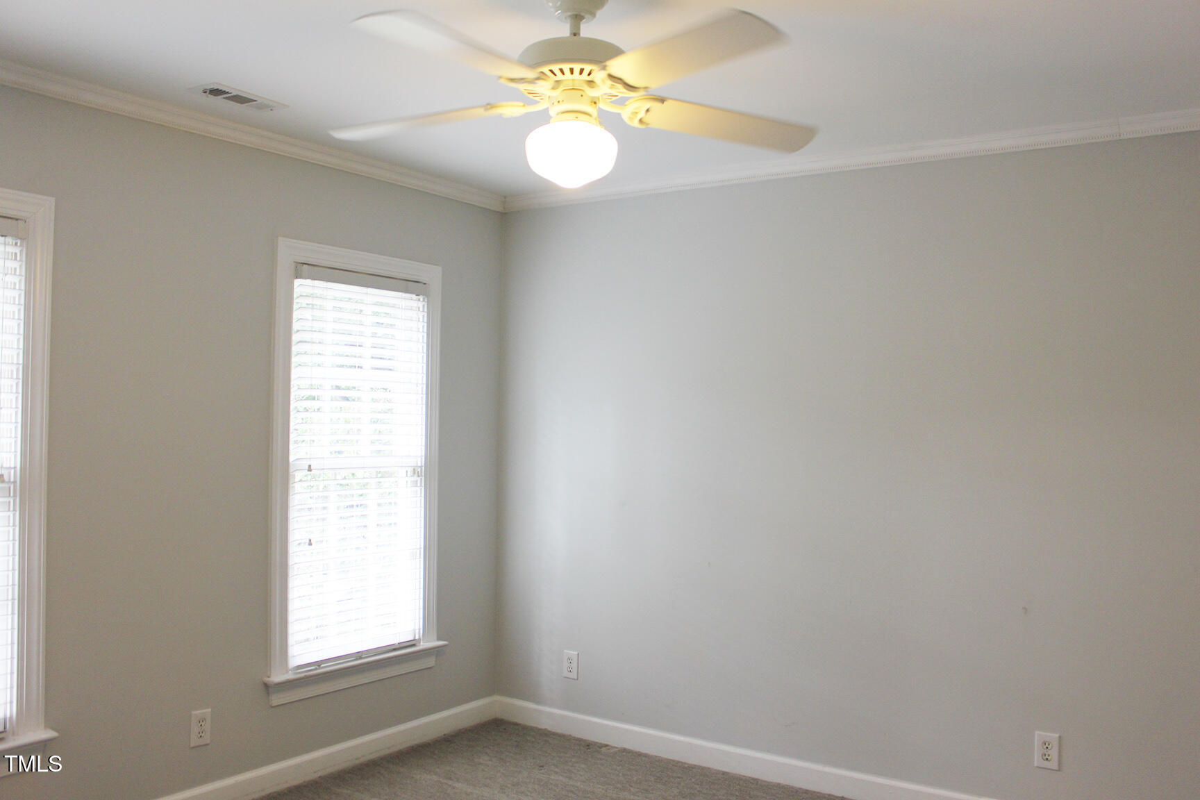 3100 Anderson Drive Raleigh, NC 27609 - Photo 24 of 31 an empty room with windows and chandelier fan