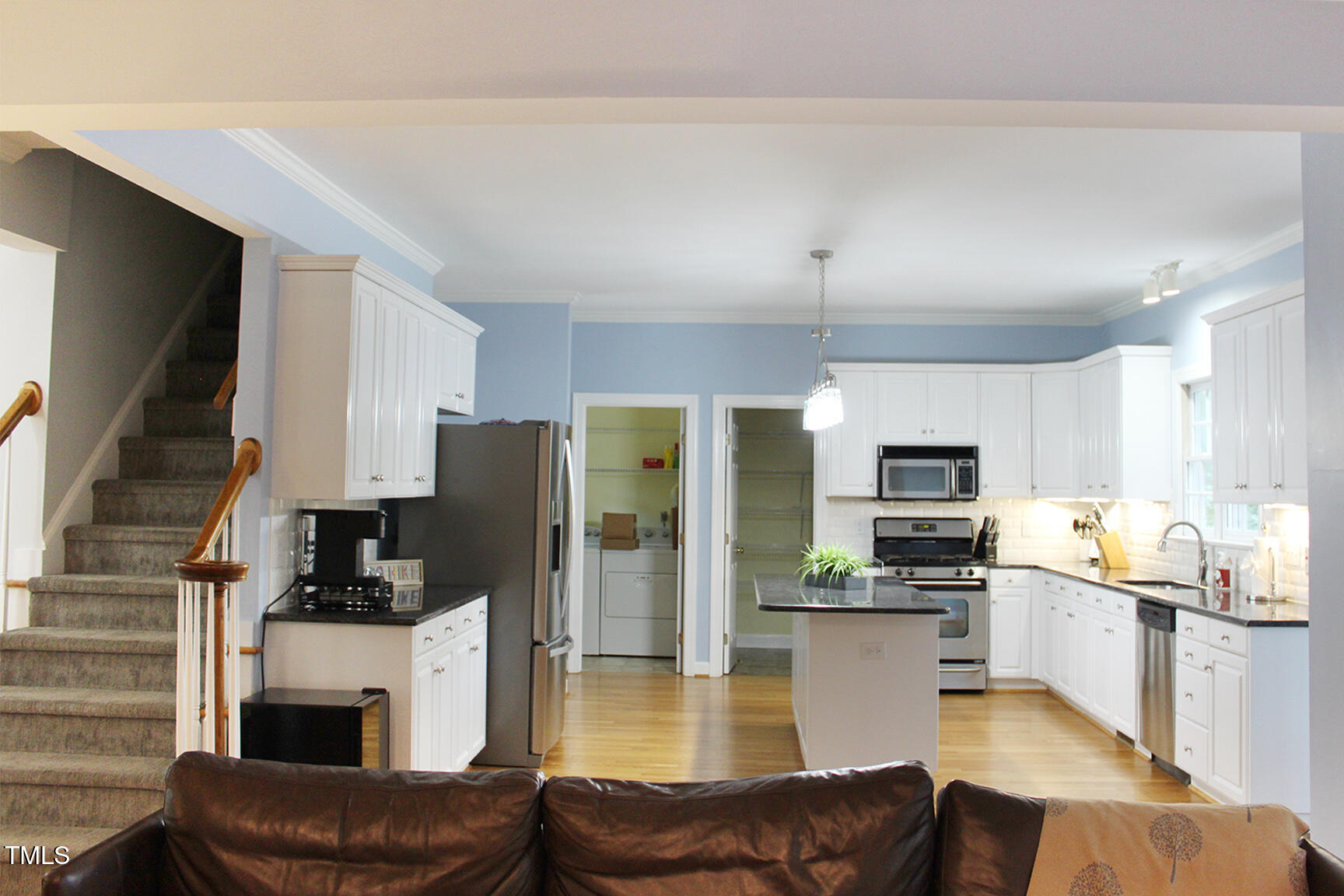 3100 Anderson Drive Raleigh, NC 27609 - Photo 10 of 31 a view of kitchen with kitchen island a refrigerator a stove a microwave oven a sink dishwasher and white cabinets with wooden floor