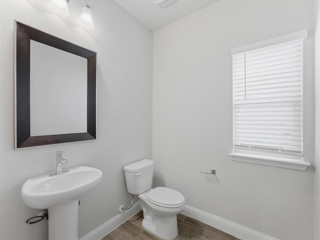 1121 Knightsbridge Road Argyle, TX 76226 - Photo 17 of 39 Pedestal sink with chrome faucet and dark wood-framed mirror