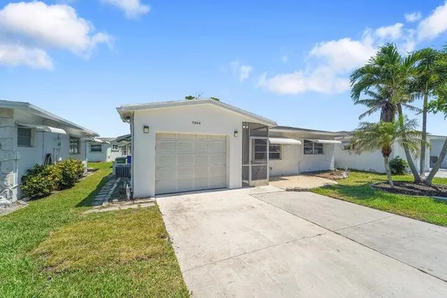 a front view of a house with a yard and potted plants