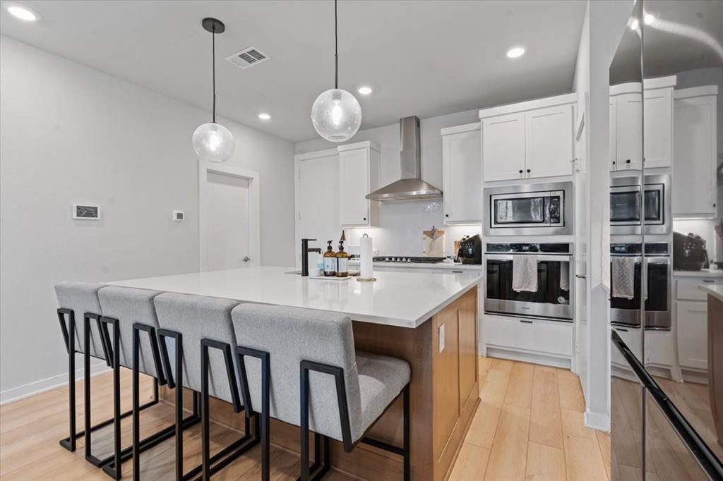 2268 Rook Drive Dallas, TX 75211 - Photo 15 of 19 a kitchen with stainless steel appliances granite countertop a sink a stove a refrigerator and island with wooden floor