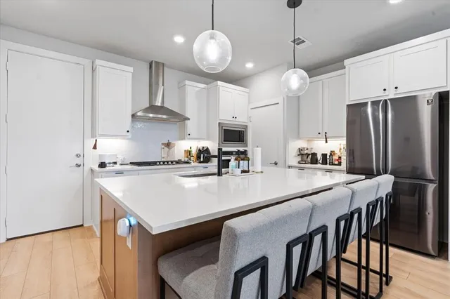 a large white kitchen with a large island
