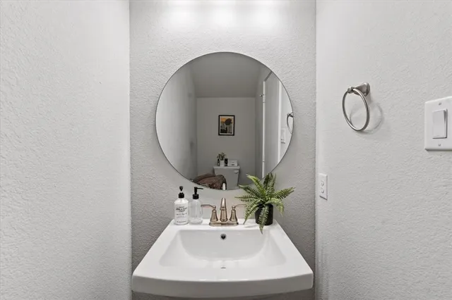 a bathroom with a toilet sink and mirror