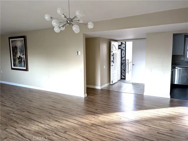a view of an empty room with window and wooden floor