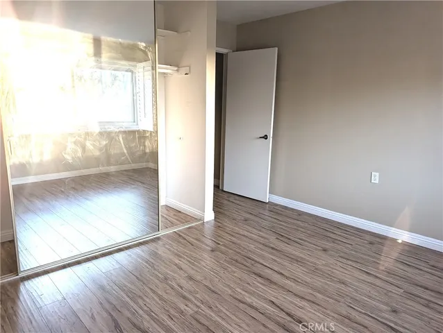 a view of a room with wooden floor and a floor to ceiling window