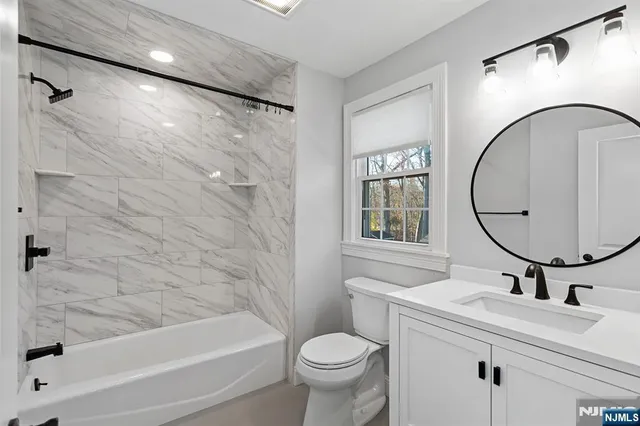 a bathroom with a sink a toilet and a mirror