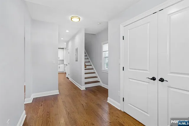 a view of a hallway with wooden floor and entryway