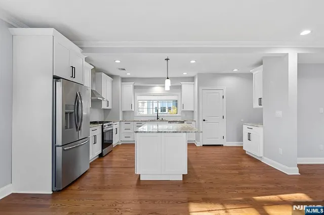 a kitchen with stainless steel appliances granite countertop a refrigerator and a stove top oven