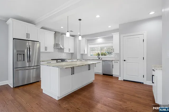 a kitchen with white cabinets and stainless steel appliances