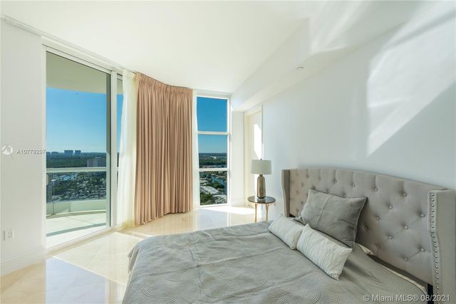 a spacious bedroom with a large bed and a large window