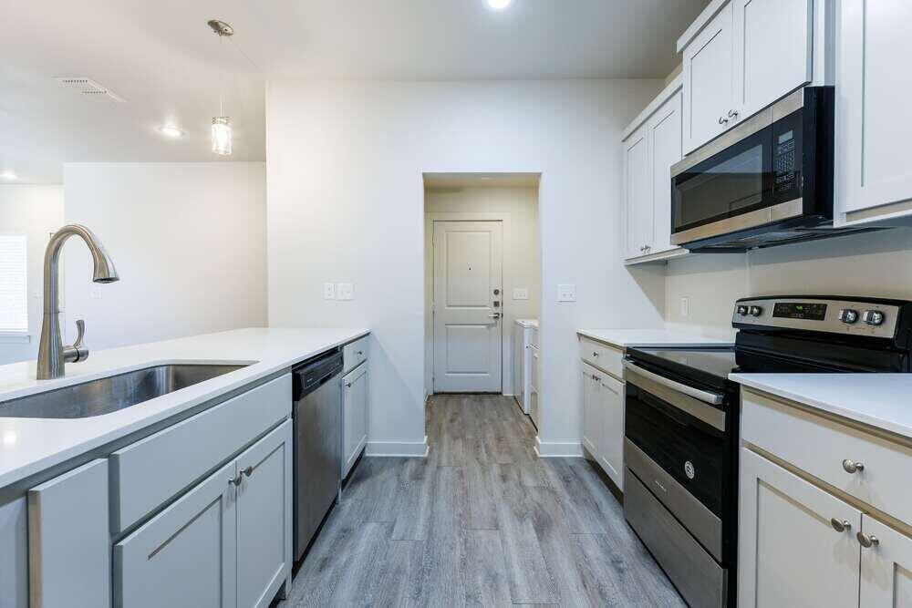 5542 Lehigh Street Lubbock, TX 79416 - Photo 3 of 12 a kitchen with white cabinets stainless steel appliances and a sink