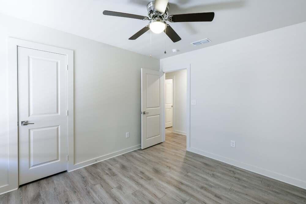 5542 Lehigh Street Lubbock, TX 79416 - Photo 9 of 12 an empty room with wooden floor and ceiling fan