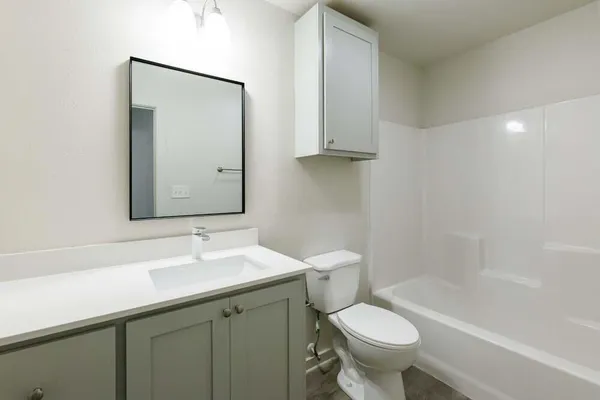 a bathroom with a sink toilet and a mirror