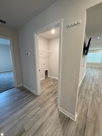 a view of a hallway with wooden floor and entryway