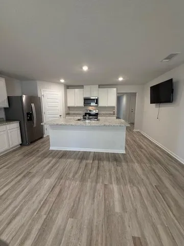 a view of kitchen with refrigerator stove microwave and cabinets