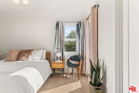 a bedroom with a bed and a large window