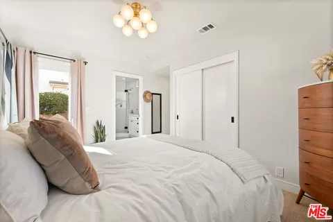 a bedroom with a bed and a chandelier