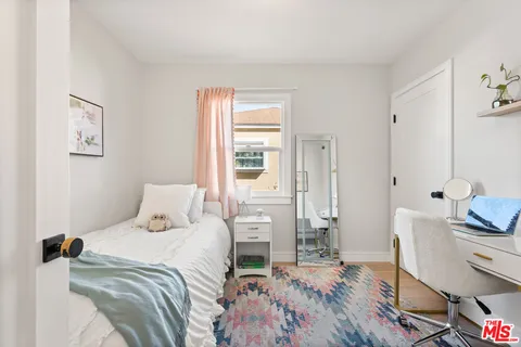 a bedroom with a bed and wooden floor