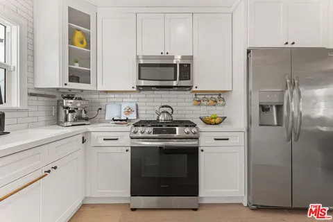 a kitchen with stainless steel appliances granite countertop a stove a refrigerator and a sink