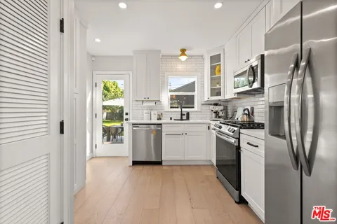 a kitchen with stainless steel appliances a refrigerator sink and stove