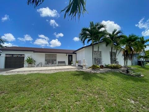 25931 Southwest 130th Avenue Homestead, FL 33032 - Photo 2 of 44 a front view of house with yard and outdoor seating