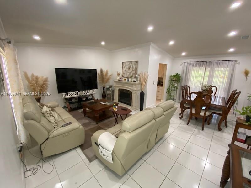 25931 Southwest 130th Avenue Homestead, FL 33032 - Photo 24 of 44 a living room with furniture a flat screen tv and a fireplace