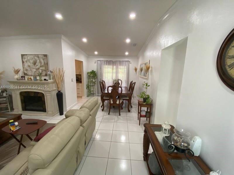 25931 Southwest 130th Avenue Homestead, FL 33032 - Photo 25 of 44 a living room with furniture a fireplace and a flat screen tv