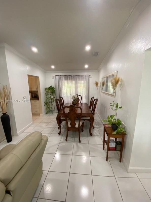 25931 Southwest 130th Avenue Homestead, FL 33032 - Photo 28 of 44 a living room with furniture a dining table and a potted plant