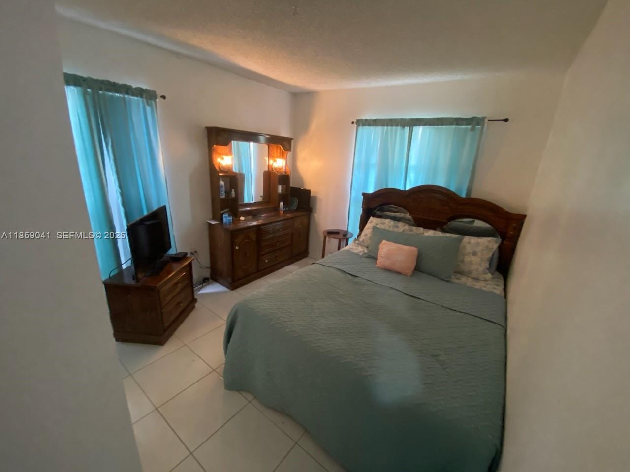 25931 Southwest 130th Avenue Homestead, FL 33032 - Photo 38 of 44 a bedroom with a bed and wooden floor