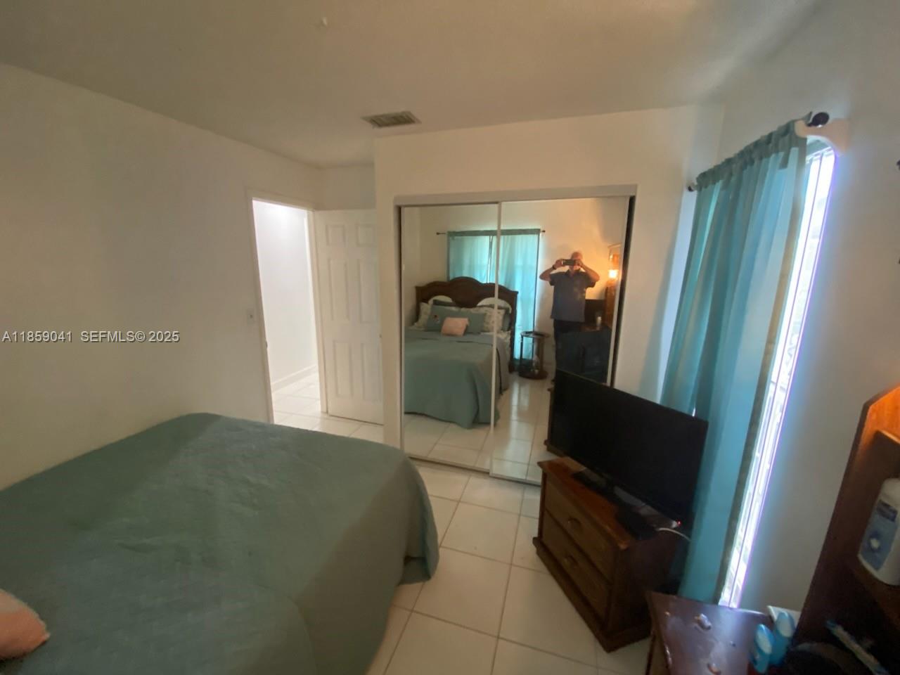25931 Southwest 130th Avenue Homestead, FL 33032 - Photo 39 of 44 a bedroom with a bed and mirror