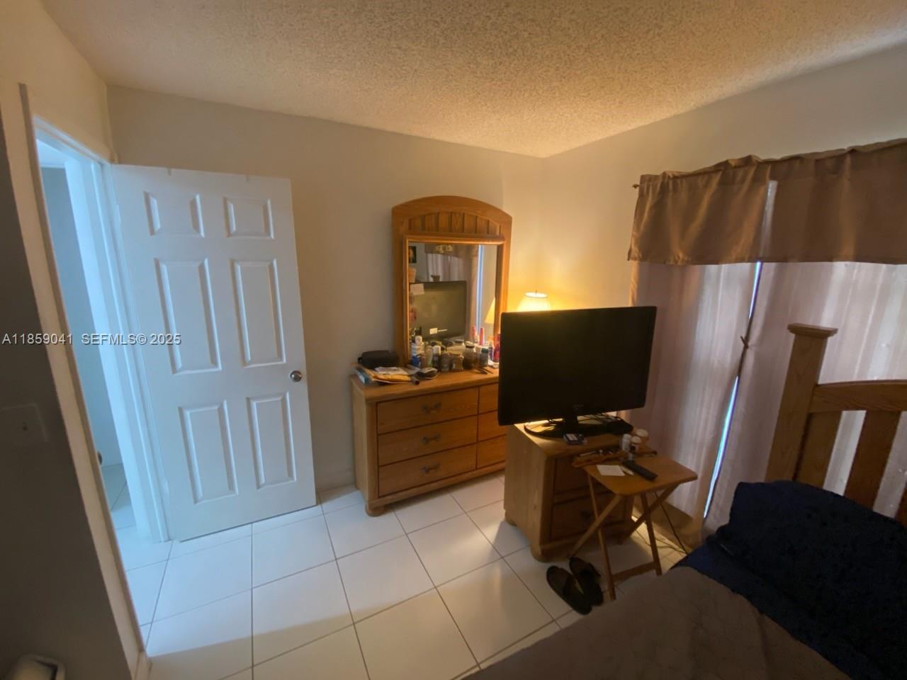 25931 Southwest 130th Avenue Homestead, FL 33032 - Photo 41 of 44 a room with a couch and a flat screen tv